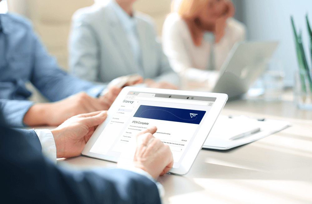 A mortgage professional holding a device during an In Person Electronic Notarization meeting with the Stavvy Platform A mortgage professional holding a device during an In Person Electronic Notarization meeting with the Stavvy Platform